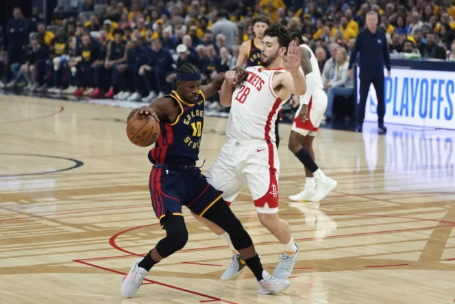 
					Forward Golden State Warriors, Jimmy Butler III mencoba melewati center Houston Rockets, Alperen Sengun pada pertandingan gim keempat babak Playoffs NBA 2025.