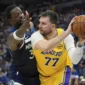 Guard Los Angeles Lakers, Luka Doncic mengoper bola melewati forward Minnesota Timberwolves, Julius Randle dalam gim ketiga Playoff NBA 2025, 26 April 2025.