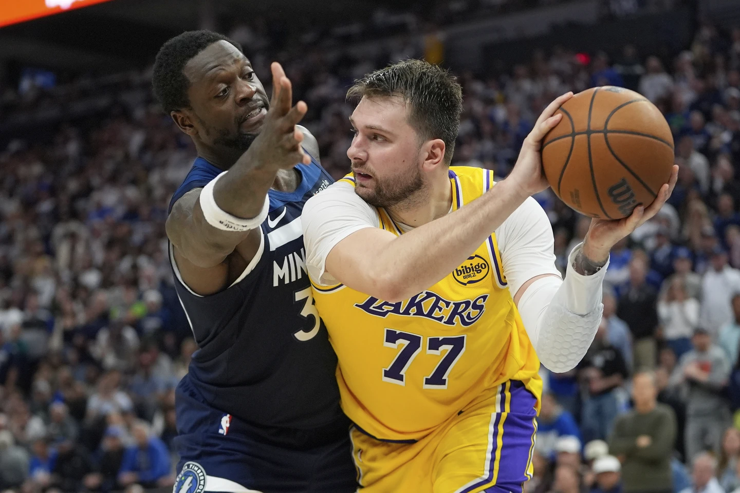 Guard Los Angeles Lakers, Luka Doncic mengoper bola melewati forward Minnesota Timberwolves, Julius Randle dalam gim ketiga Playoff NBA 2025, 26 April 2025.