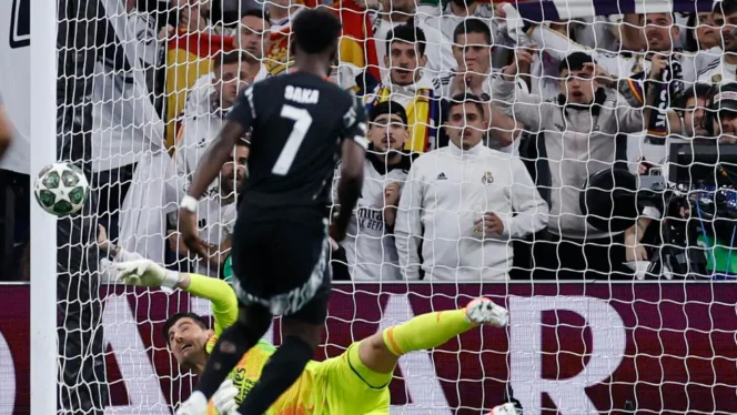 
					Thibaut Courtois menggagalkan tendangan penalti Bukayo Saka.