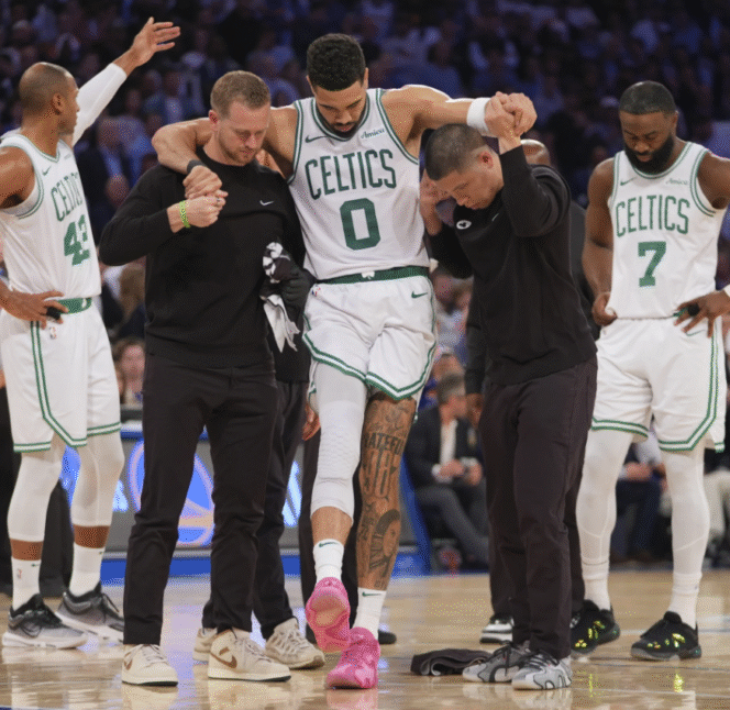 
					Jayson Tatum (0) dipandu keluar lapangan oleh tim pelatih Boston Celtics, setelah mengalami cedera engkel kaki kanan pada gim 4 antara Boston Celtics dan New York Knicks semifinal wilayah Timur playoff NBA 2025. Selasa pagi WIB, 13 Mei 2025.