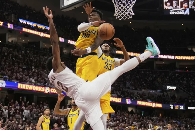 
					Momen ketika De'Andre Hunter (12) dari Cleveland Cavaliers terjatuh setelah tembakannya diblok oleh Bennedict Mathurin (00) dari Indiana Pacers di babak kedua.