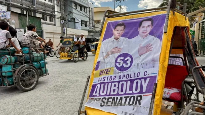 
					Poster kampanye Duterte bersama pastor Apollo Quiboloy terpajang di Manila.