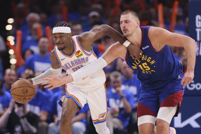 
					Shai Gilgeous-Alexander (kiri) mencoba melewati Nikola Jokic (15) pada game 5 semifinal wilayah Barat Playoff NBA di Oklahoma City. Rabu pagi WIB, 14 Mei 2025.