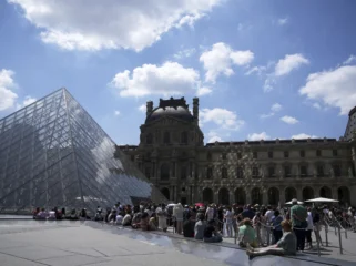 Turis mengantre di luar Museum Louvre yang gagal dibuka tepat waktu pada Senin, 16 Juni 2025, di Paris. (foto: AP/Christophe Ena)