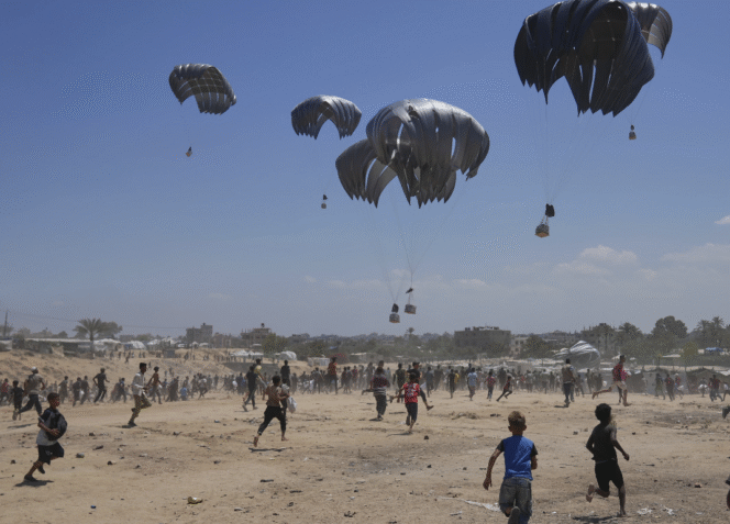 
					Warga Palestina berlarian menuju bantuan kemanusiaan yang dijatuhkan melalui parasut ke wilayah Zawaida di Jalur Gaza tengah. Senin, 4 Agustus 2025. (foto: AP/Abdel Kareem Hana)