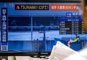 Peringatan waspada tsunami tayang di beberapa media di Jepang setelah gempa bermagnitudo 7,7 mengguncang wilayah timur laut negara itu. (foto: Pillip Fong/AFP)