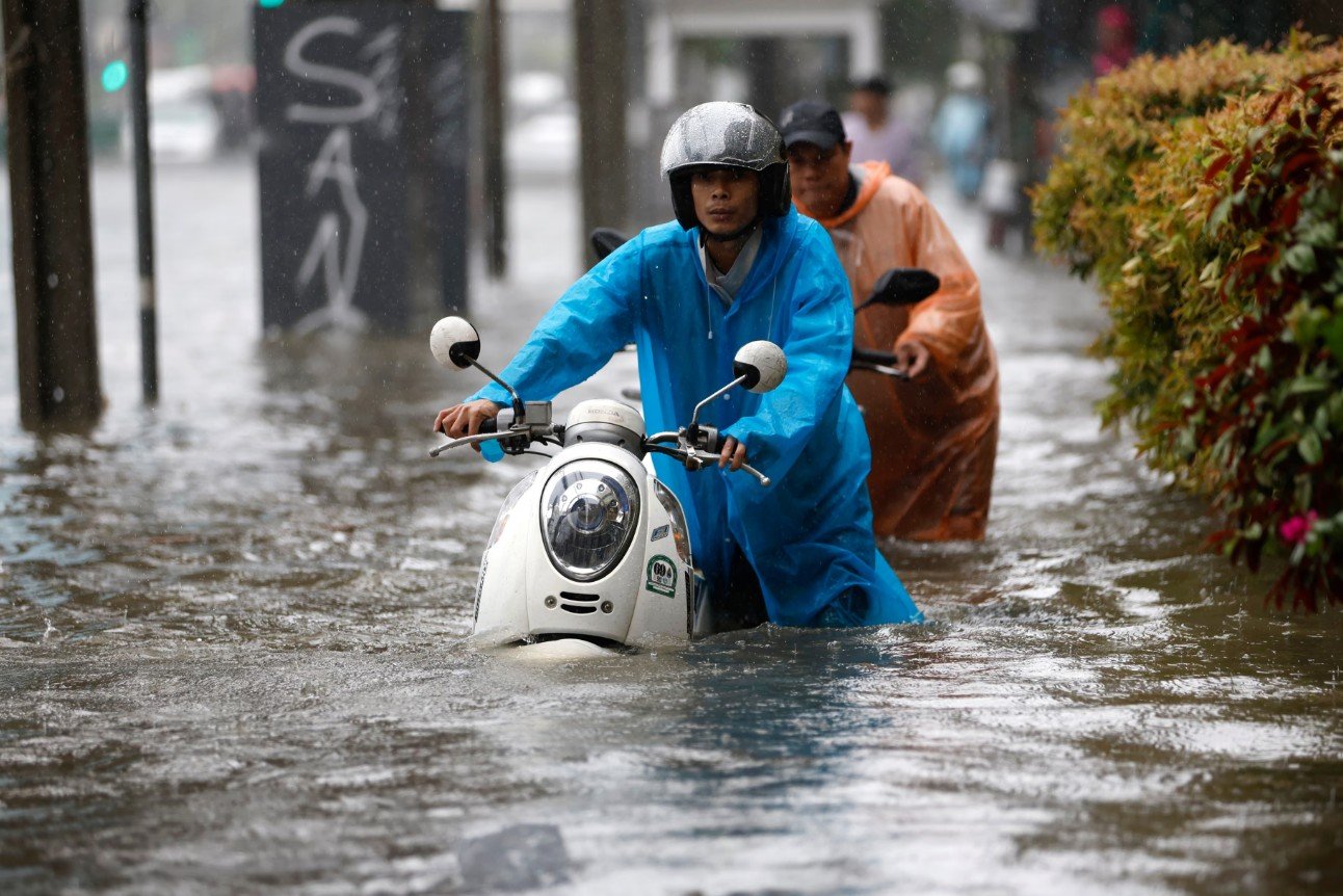 Seorang warga Bangkok tampak sedang mendorong sepeda motornya karena banjir besar yang melanda di Bangkok, Thailand. Minggu, 27 September 2026. (EPA/Rungroj Yongrit)
