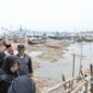 Petugas dan warga membersihkan tumpukan sampah di Sungai Kalimati, Desa Kedungrejo, Kecamatan Muncar, Banyuwangi.