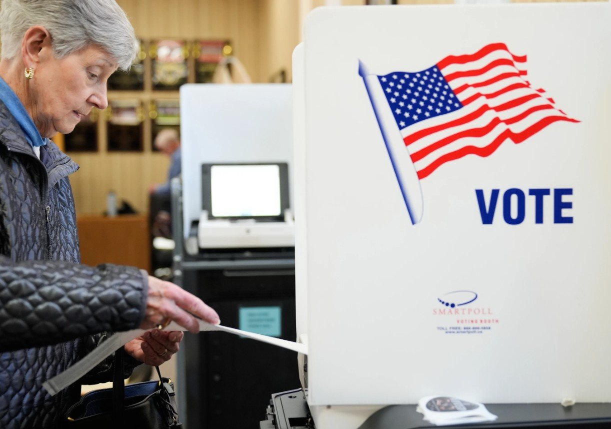 Seorang wanita memasukkan surat suaranya ke dalam mesin pemindai di lokasi pemungutan suara awal di Haverstraw, N.Y. Senin, 26 Oktober 2026. (AP Photo/Seth Wenig)